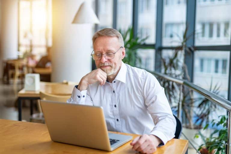 Vanhempi asiantuntija läppärin äärellä miettelijäänä